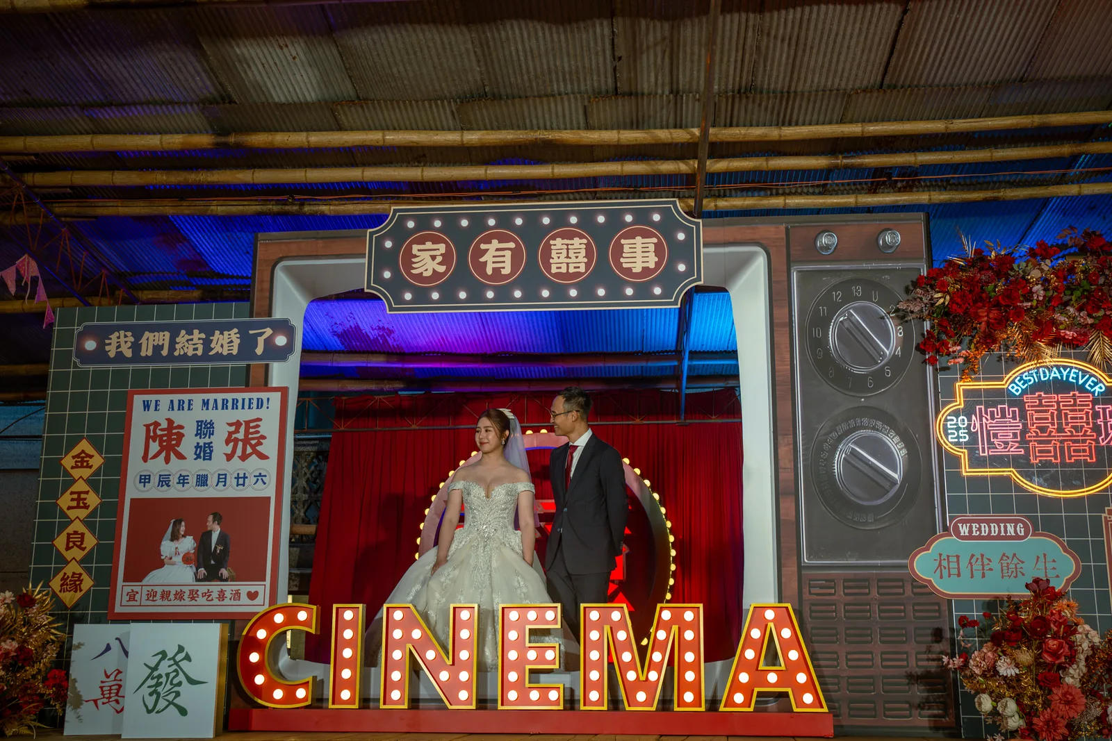 空軍一村流水席婚禮舞台，新人站在復古電視主題背板前，前方有 CINEMA 燈箱。